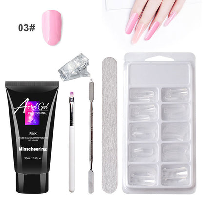 Woman applying acrylic nail extension using professional nail brush from complete kit.